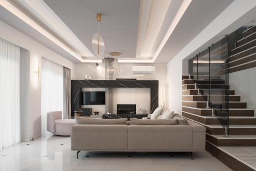 a living room with a couch and a staircase at Villa Kalliston in Rethymno Town
