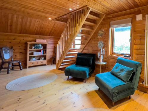 a living room with a staircase and two chairs at Freedom Lodge Great Ayton Yorkshire in Great Ayton