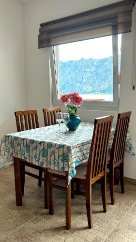 a dining room table with a vase of flowers on it at Boka Dream view Apartments in Prčanj