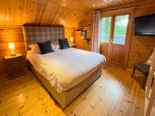 a bedroom with a bed in a wooden cabin at Freedom Lodge Great Ayton Yorkshire in Great Ayton