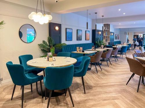 a restaurant with blue chairs and tables in a room at Freedom Lodge Great Ayton Yorkshire in Great Ayton