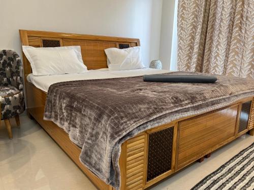 a large bed with a wooden headboard in a bedroom at Royal orbit studio in Ghaziabad