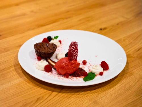 a white plate with dessert on a wooden table at Hotel Lamm in Heimbuchenthal