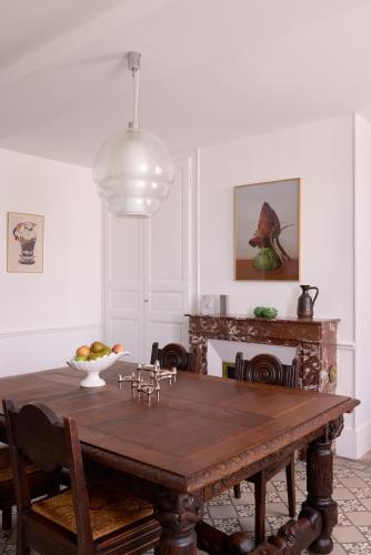 une salle à manger avec une table en bois et une cheminée dans l'établissement La maison de Crèvecoeur, à La Croix-Saint-Leufroy