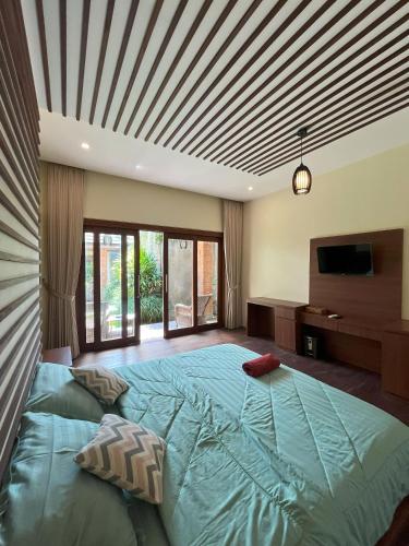 a bedroom with a large bed with a wooden ceiling at Riverside Villa Tanah Lot by Smart Digital in Munggu