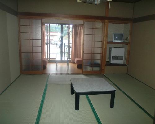 a room with a bench in the middle of a room at Mizubaso in Gujo