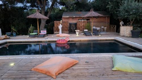 - une piscine avec des oreillers sur une terrasse en bois dans l'établissement Studio 1 à 2personnes, à Nîmes