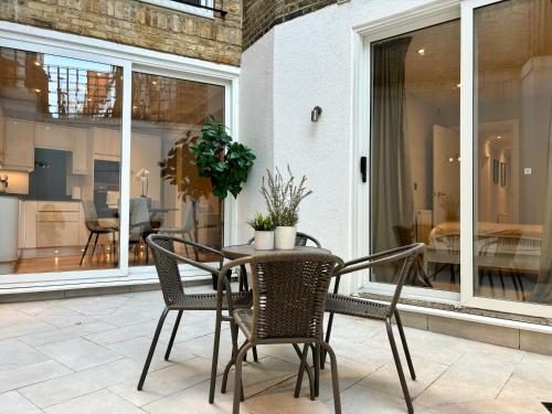 a patio with a table and chairs and a dining room at The Cadogan Suite by Harrods in London