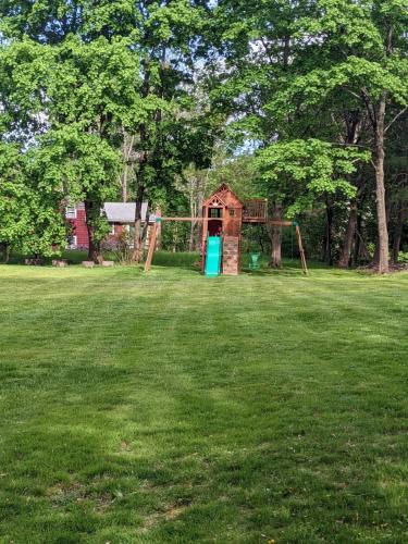 a playground in the middle of a grass field at Spacious 4 bedroom home with large yard in Wayland