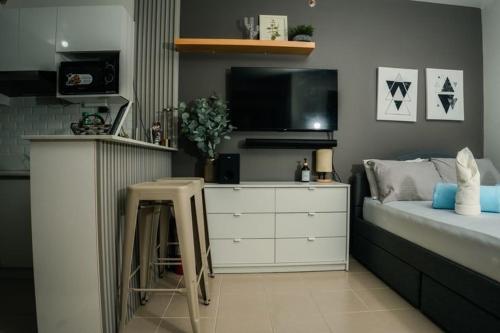 a bedroom with a bed with a dresser and a tv at KaribuBnb in Lapu Lapu City