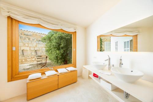 une salle de bain avec deux lavabos et une grande fenêtre dans l'établissement Casa Con Piscina En Selva, à Selva