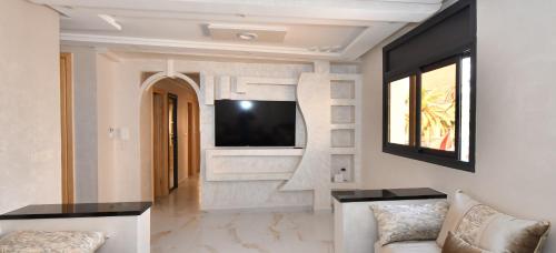 a living room with a tv on a wall at Appartement Riyam in Al Hoceïma