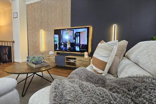 a living room with a couch and a flat screen tv at Shop, Soak &Sleep Galleria 3BR Retreat Private Jacuzzi in Houston