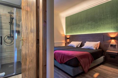 a bedroom with a bed and a glass shower at Alojamento Local - Miradouro do Castelo in Castro Laboreiro