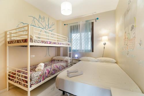 a bedroom with two beds and a bunk bed at Apartamento Costa De La Luz in Rota
