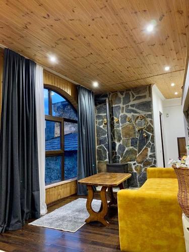 a living room with a table and a window at Guest House Keti Margiani Mestia in Mestia