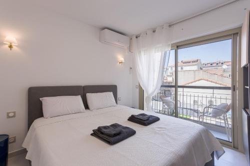 une chambre avec un lit blanc avec deux serviettes dessus dans l'établissement 7 Pradignac Full 3bdrs by Halldis, à Cannes