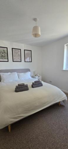 a bedroom with a large bed with two towels on it at Salisbury City Centre 2-Bedroom Serviced Accommodation-Apartment - PennyVille in Salisbury