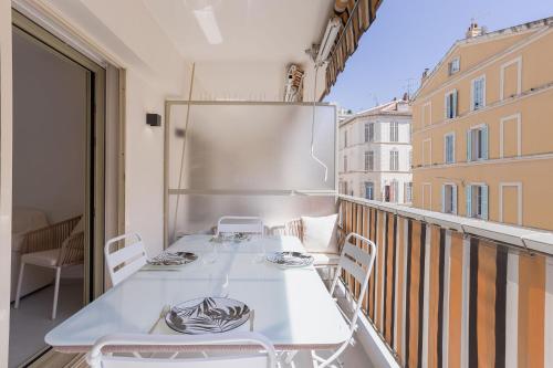 Elle comprend un balcon doté d'une table et de chaises blanches. dans l'établissement 7 Pradignac Full 3bdrs by Halldis, à Cannes