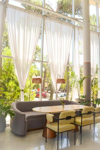 a living room with a couch and a table and chairs at Hotel Zentiva Pinamar in Pinamar