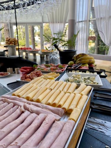 a buffet with lots of hot dogs and other foods at Hotel Zentiva Pinamar in Pinamar