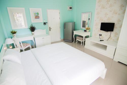 a bedroom with a white bed and a television at Boonsiri Boutique Hotel in Si Sa Ket