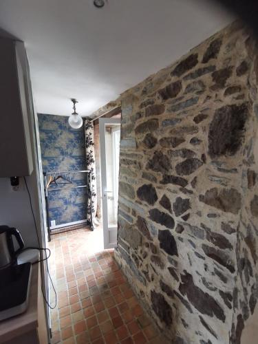 Cette chambre est dotée d'un mur en pierre et d'un couloir. dans l'établissement STUDIO Beaulieu, à Cesson-Sévigné