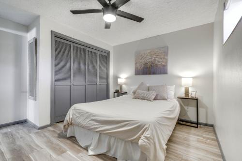 a white bedroom with a bed and a ceiling fan at Central Cedar City Apartment Walk to SUU! in Cedar City