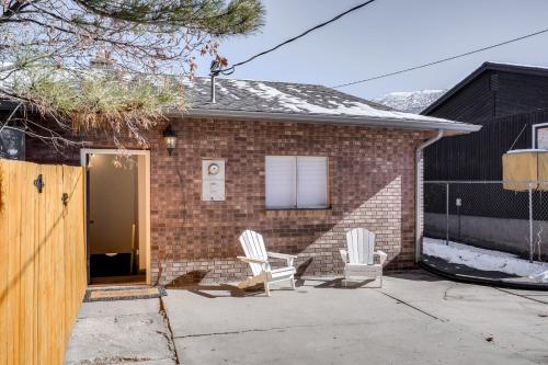 a brick house with two white chairs on a driveway at Central Cedar City Apartment Walk to SUU! in Cedar City