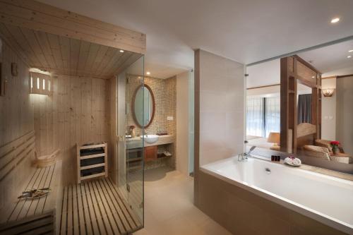 a bathroom with a tub and a sink and a mirror at MK Premier Boutique Hotel in Hanoi