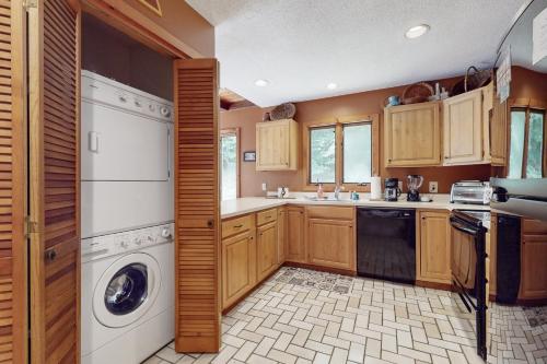a kitchen with wooden cabinets and a washer and dryer at Suntec Getaway in Dover