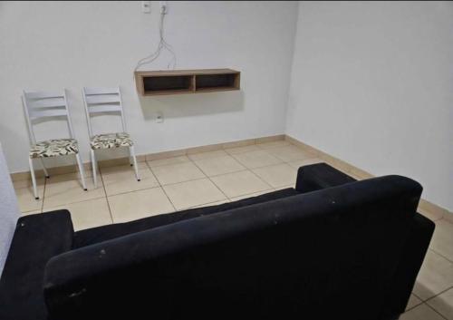 una sala de estar con un sofá y dos sillas en casa de temporada, en Goiânia