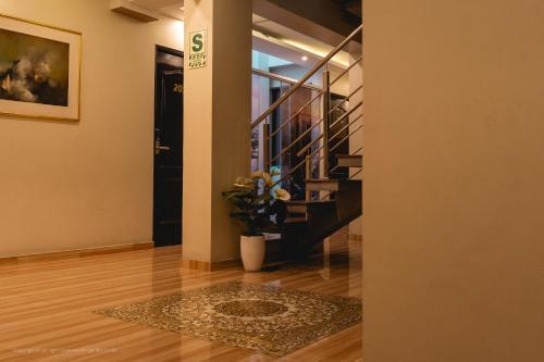 a hallway with a staircase and a vase with a plant at Hotel Portomor in Lima