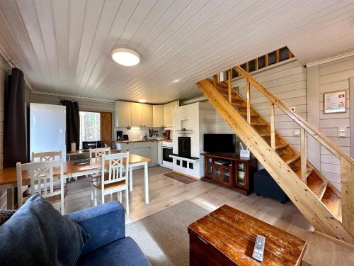 a living room with a staircase and a kitchen at Hillside Cottage in Ivalo