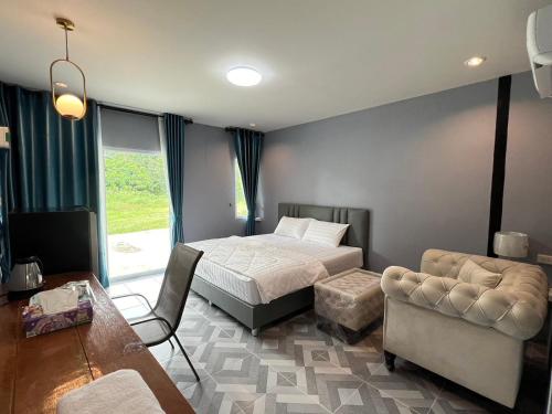 a bedroom with a bed and a couch and a table at Feel good at Nangrong in Ban Nong Samet