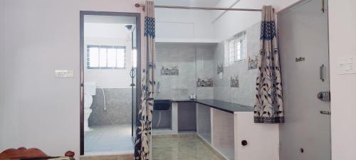 baño con lavabo y puerta de cristal en Nature stay Mysore, en Mandya