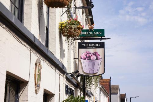 a sign on the side of a building with a basket of fruit at The Bushel by Greene King Inns in Bury Saint Edmunds
