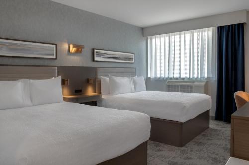 a hotel room with two beds and a window at Hampton Inn By Hilton Winnipeg Downtown in Winnipeg