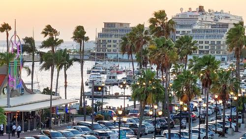 a parking lot with cars parked in front of a harbor at Bocobay Penthouse 4BR 4BA with Rooftop Pool in Oranjestad
