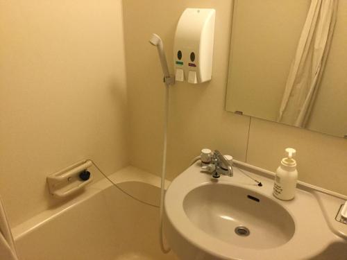 W łazience znajduje się umywalka oraz prysznic z lustrem. w obiekcie Ilmare Unarizaki w mieście Iriomote