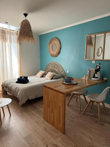 una camera da letto con un letto, un tavolo e delle sedie di Studio Boho-Chic en centre ville a Moulins