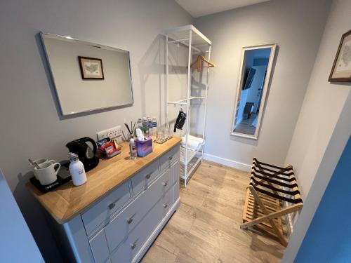 a bathroom with a dresser and a mirror at Seafront BnB at Botany in Kent