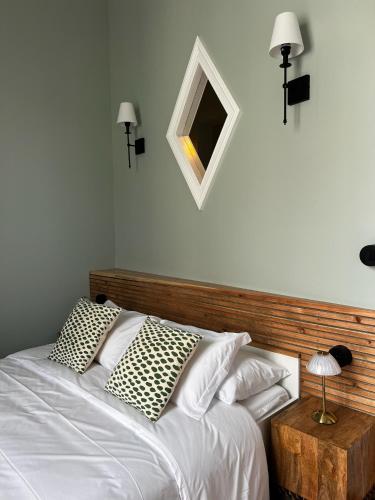 a bedroom with a white bed with a wooden headboard at Hommage in Horta