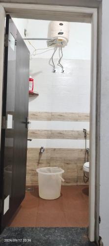 a bathroom with a toilet and a person on the wall at Blue mount stay in Gūdalūr