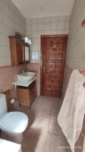 a bathroom with a toilet and a sink and a door at Casa Jabero in Nívar