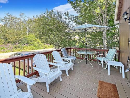 eine Terrasse mit Stühlen, einem Tisch und einem Sonnenschirm in der Unterkunft Beach Daze Cottage Brought to you by GetAway Vacations in York