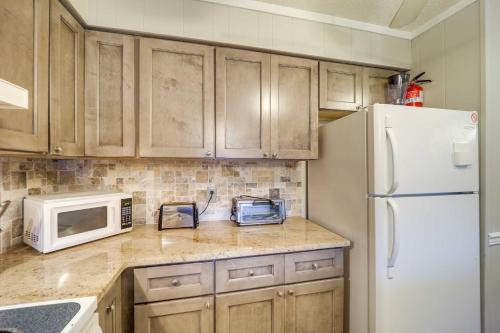 a kitchen with wooden cabinets and a white refrigerator at Hike, Golf and Ski Beech Mtn Condo with Resort Perks! in Beech Mountain