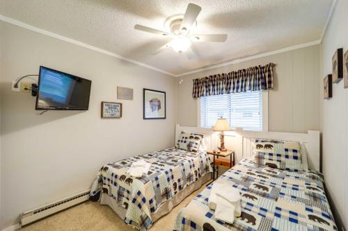 a bedroom with two beds and a flat screen tv at Hike, Golf and Ski Beech Mtn Condo with Resort Perks! in Beech Mountain