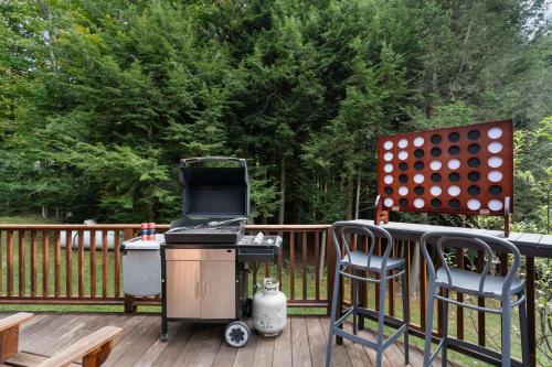 a grill and two chairs on a deck at Luxury Chalet, Firepit, Sauna, Pet Friendly, 5 mins to Windham Mtn resort in Windham