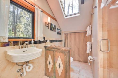 a bathroom with a sink and a toilet and a window at Patio and Mtn Views Peaceful Sedona Retreat in Sedona